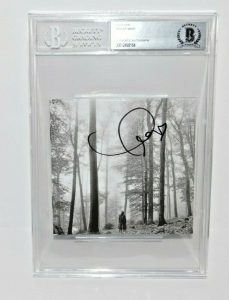 TAYLOR SWIFT SIGNED (FOLKLORE) CD COVER BECKETT ENCAPSULATED BAS 00012498164  COLLECTIBLE MEMORABILIA