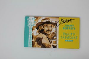JIMMY BUFFETT SIGNED AUTOGRAPH “BURIED TREASURE VOL 1” SONG BOOK -MARGARITAVILLE  COLLECTIBLE MEMORABILIA