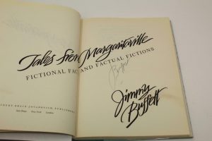 JIMMY BUFFETT SIGNED AUTOGRAPH “TALES FROM MARGARITAVILLE” BOOK – VERY RARE  COLLECTIBLE MEMORABILIA