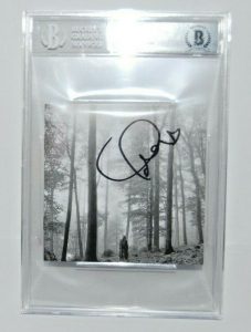 TAYLOR SWIFT SIGNED (FOLKLORE) CD COVER BECKETT ENCAPSULATED BAS 00012549391  COLLECTIBLE MEMORABILIA