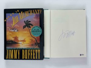 JIMMY BUFFETT SIGNED AUTOGRAPH “WHERE IS JOE MERCHANT” BOOK – MARGARITAVILLE BAS COLLECTIBLE MEMORABILIA